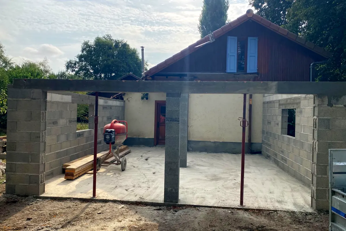 Murs en blocs béton montés sur un chantier de l’entreprise : poteaux, linteau en place, étais, dalle béton, bétonnière